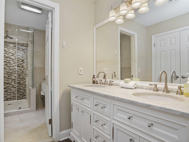 bathroom featuring tile patterned floors, vanity, toilet, and a shower with door