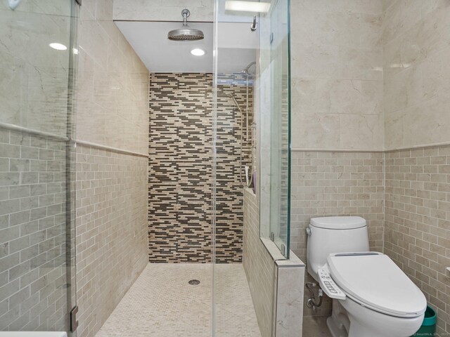 bathroom featuring walk in shower, tile walls, and toilet