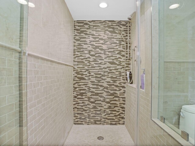 bathroom with tile walls, toilet, and walk in shower