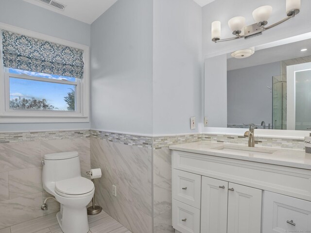 bathroom with walk in shower, vanity, toilet, and tile walls