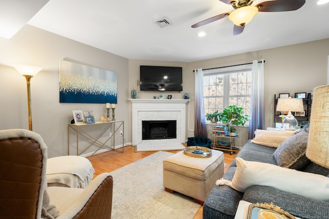 living room with light hardwood / wood-style floors and ceiling fan