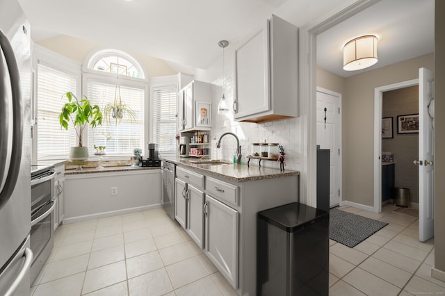 kitchen with sink, light tile patterned floors, appliances with stainless steel finishes, backsplash, and white cabinets