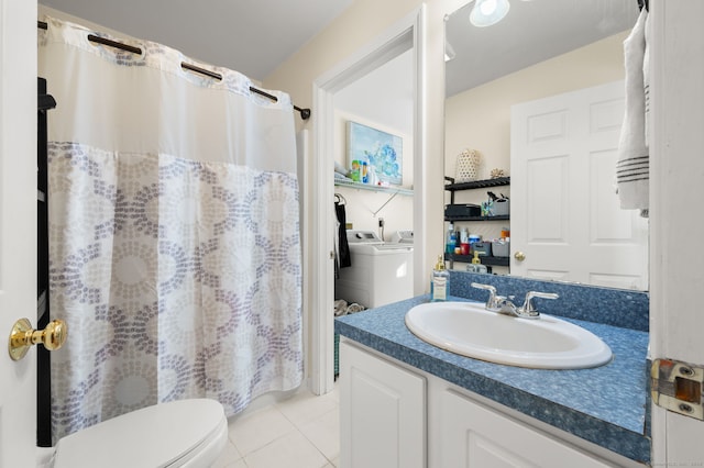 bathroom featuring tile patterned flooring, washing machine and dryer, vanity, and toilet