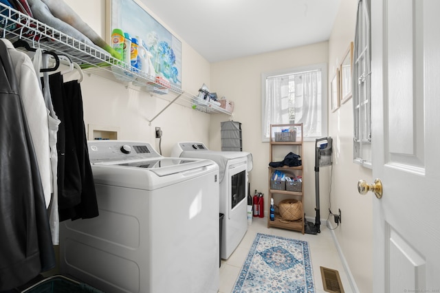 washroom featuring washer and clothes dryer and light tile patterned floors