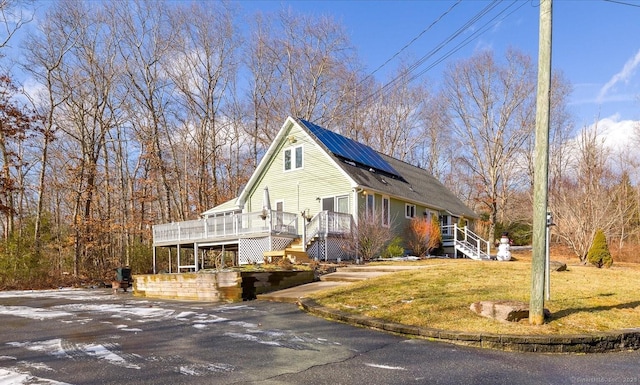 view of front of property with a wooden deck and a front yard