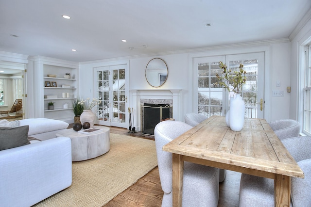 living room with ornamental molding, wood-type flooring, and a premium fireplace