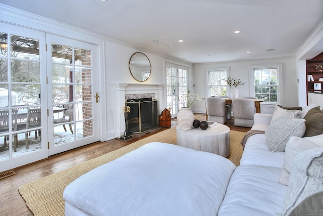 living room with a fireplace, crown molding, and hardwood / wood-style floors