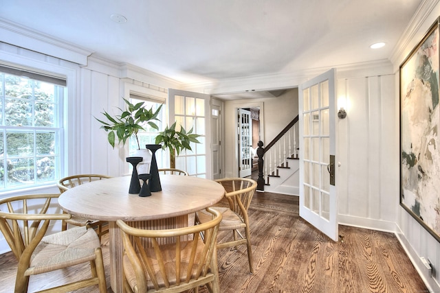 dining space with french doors, crown molding, and dark hardwood / wood-style flooring