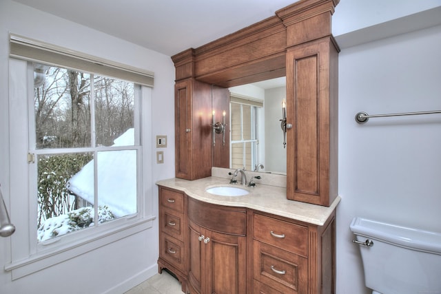 bathroom featuring toilet, vanity, and a healthy amount of sunlight