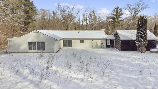 view of snow covered rear of property