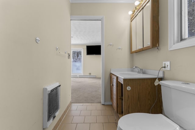 bathroom with tile patterned flooring, heating unit, vanity, a healthy amount of sunlight, and toilet