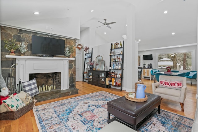 living room featuring ceiling fan, lofted ceiling, and light hardwood / wood-style floors