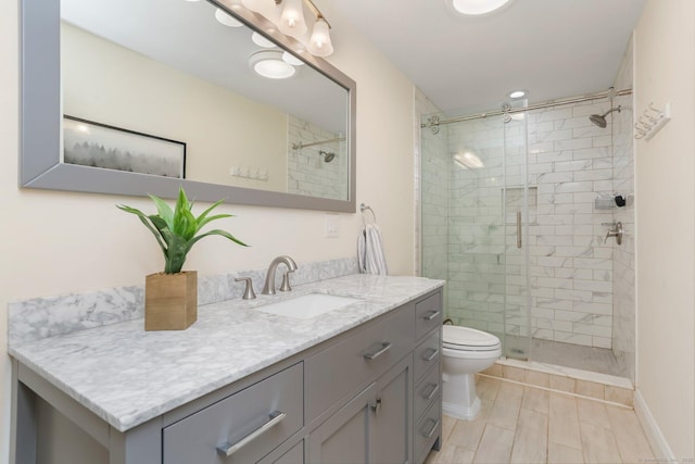 bathroom with vanity, a shower with door, and toilet