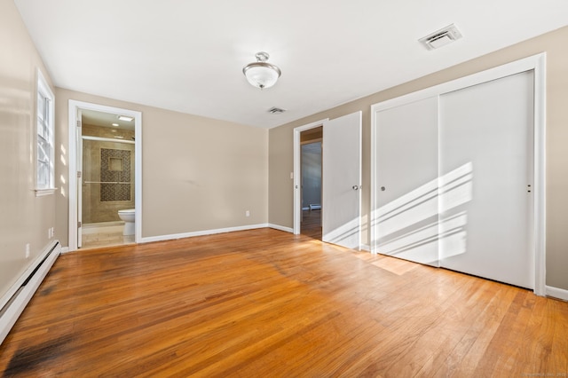 empty room with a baseboard heating unit and light wood-type flooring