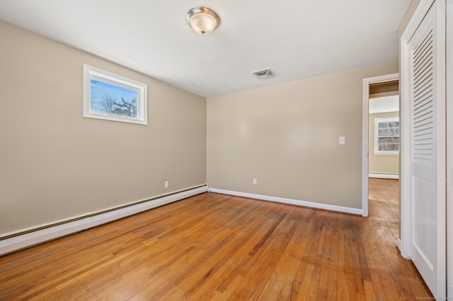 interior space with a baseboard radiator and light hardwood / wood-style floors