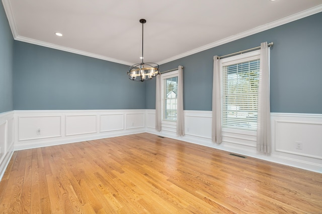 spare room featuring crown molding, an inviting chandelier, and light hardwood / wood-style flooring