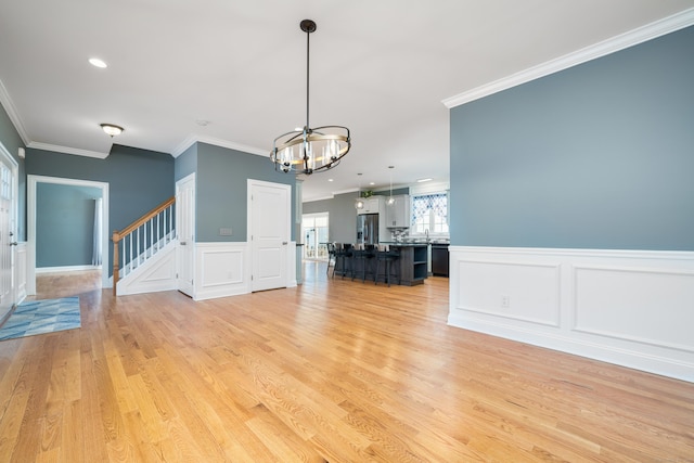 interior space featuring crown molding, a chandelier, and light hardwood / wood-style flooring