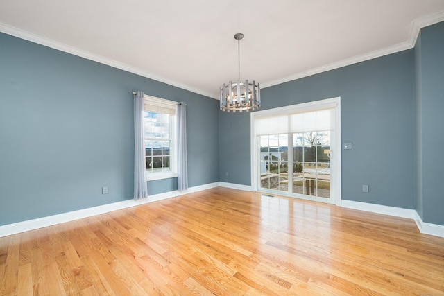 empty room featuring plenty of natural light, an inviting chandelier, and light hardwood / wood-style floors