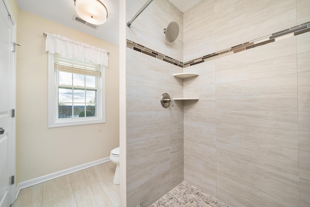 bathroom featuring tile patterned floors, toilet, and tiled shower