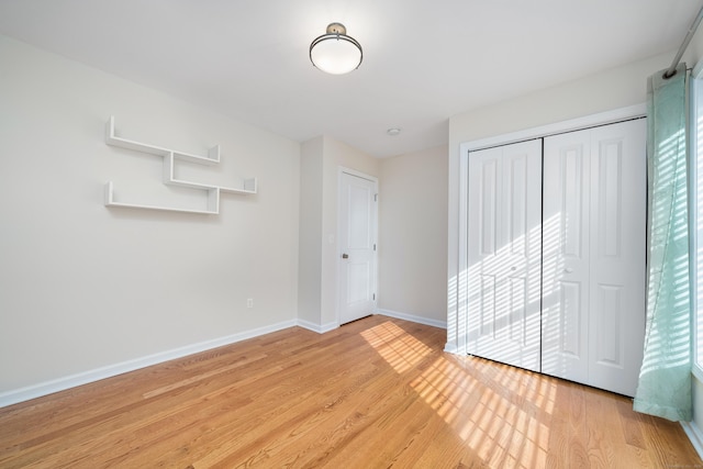 unfurnished bedroom featuring a closet and light hardwood / wood-style flooring