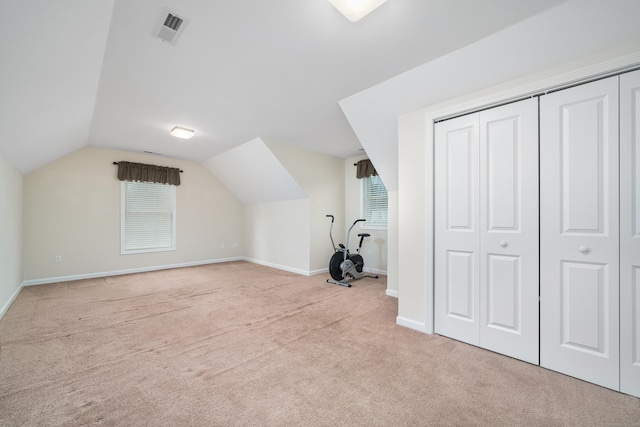 additional living space featuring lofted ceiling and light carpet