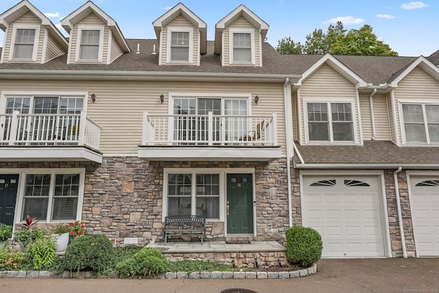 view of front of property with a garage, a shingled roof, and driveway