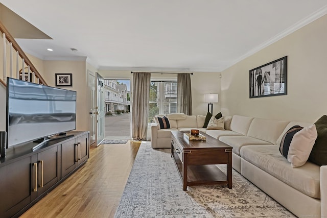 living area featuring light wood-style floors, recessed lighting, crown molding, and stairs