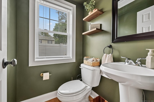 bathroom with toilet, baseboards, and a sink