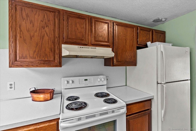 kitchen with white appliances and a textured ceiling