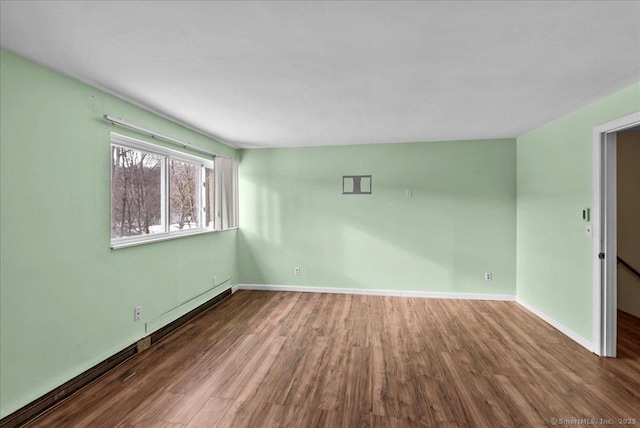 unfurnished room with dark wood-type flooring