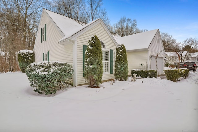 snow covered property with a garage