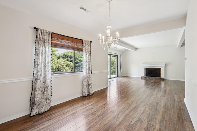 957A Heritage Vlg, Southbury, CT 06488 - unfurnished living room with a chandelier, wood finished floors, a fireplace, baseboards, and beamed ceiling