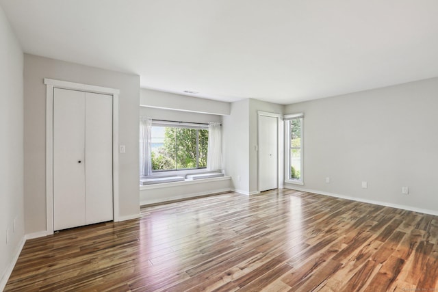 957A Heritage Vlg, Southbury, CT 06488 - unfurnished bedroom featuring two closets, wood finished floors, and baseboards