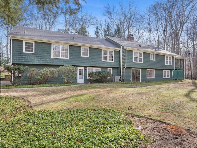 view of front of home with central AC and a front yard