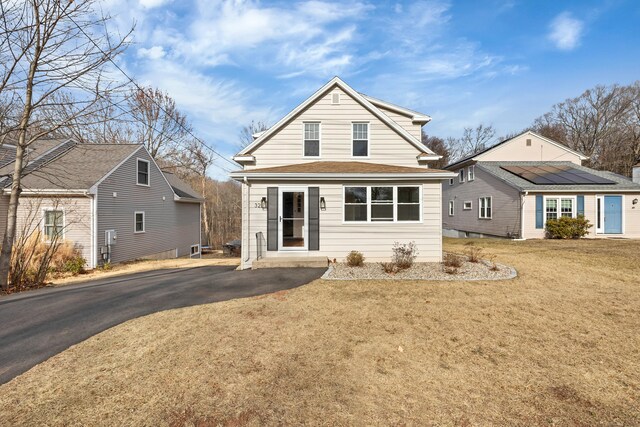 view of front of property featuring a front yard and solar panels