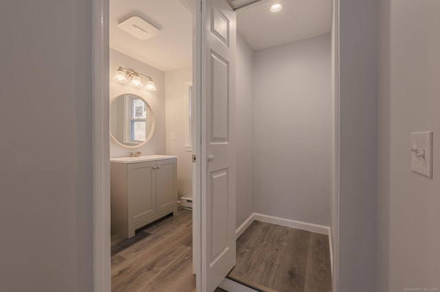 bathroom with a baseboard radiator, vanity, and hardwood / wood-style floors