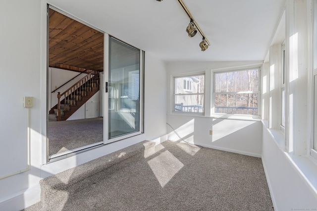 unfurnished sunroom with rail lighting