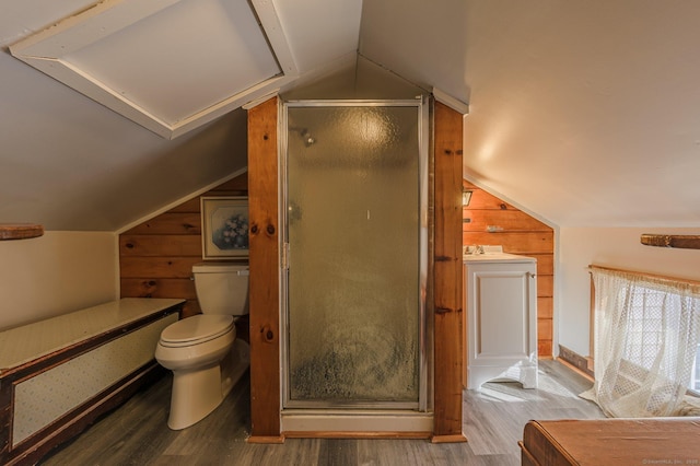 bathroom featuring vaulted ceiling, toilet, a shower with shower door, and hardwood / wood-style floors