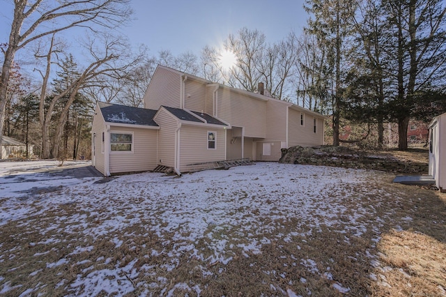 view of snow covered back of property