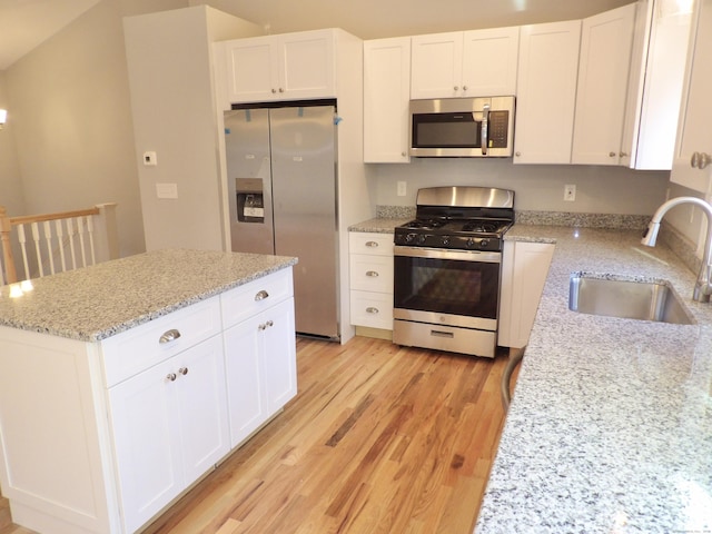 kitchen with light stone counters, sink, stainless steel appliances, and white cabinets