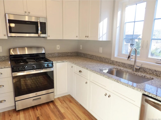 kitchen with white cabinetry, sink, and stainless steel appliances