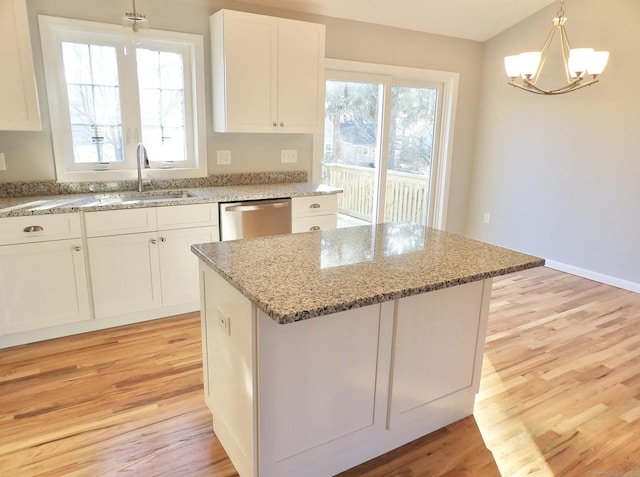 kitchen featuring white cabinetry, dishwasher, sink, and a kitchen island