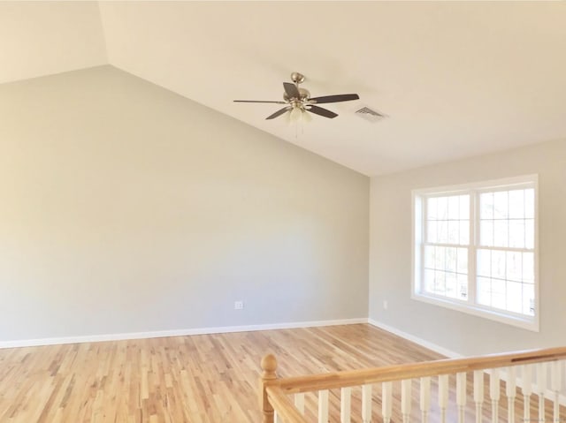 empty room with lofted ceiling, wood-type flooring, and ceiling fan