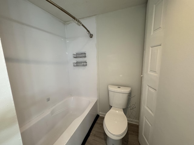 bathroom featuring hardwood / wood-style flooring, bathing tub / shower combination, and toilet