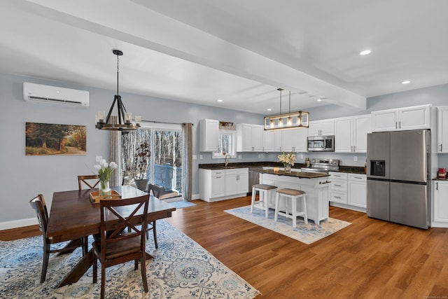 dining room with sink, light hardwood / wood-style flooring, a wall unit AC, a notable chandelier, and beamed ceiling