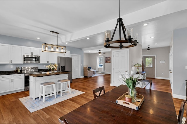 dining area featuring wood-type flooring, a healthy amount of sunlight, and ceiling fan