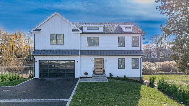 modern inspired farmhouse with a garage and a lawn