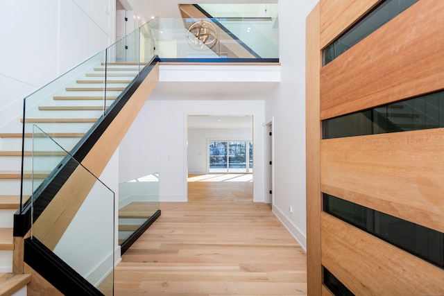 stairs featuring hardwood / wood-style flooring and a towering ceiling