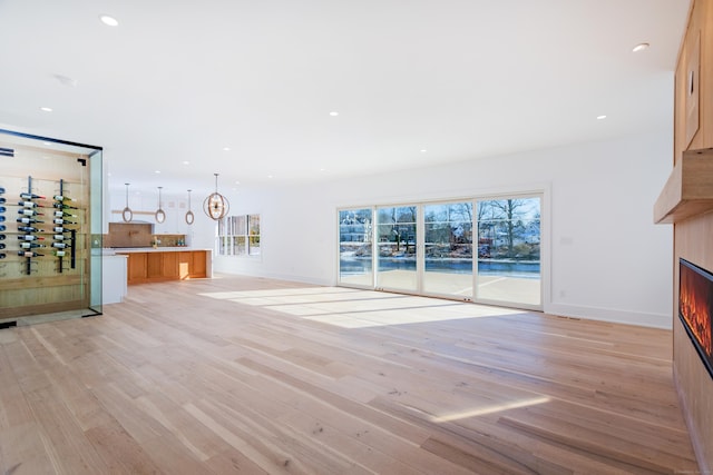 unfurnished living room with light hardwood / wood-style floors and a healthy amount of sunlight