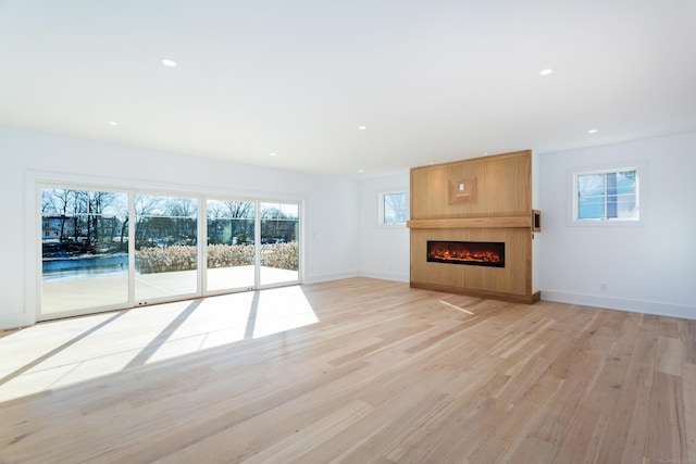 unfurnished living room with light hardwood / wood-style flooring and a large fireplace